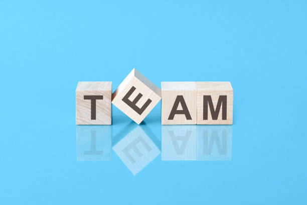 istock team word from wooden blocks with letters, front view on blue background 1357928960