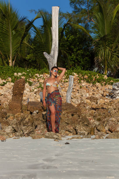 istock Girl walks on the beach 1357929135