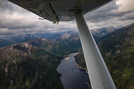 looking out window of float plane over Alaskan mountain range