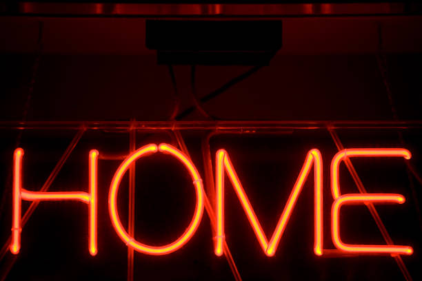 HOME lit neon sign, close-up lights, full frame black background with orange letters
