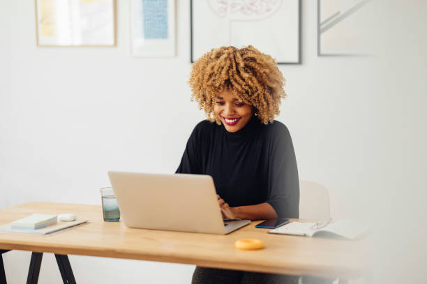 istock Beautiful African American Woman Using her Laptop While Working from Home 1357935450