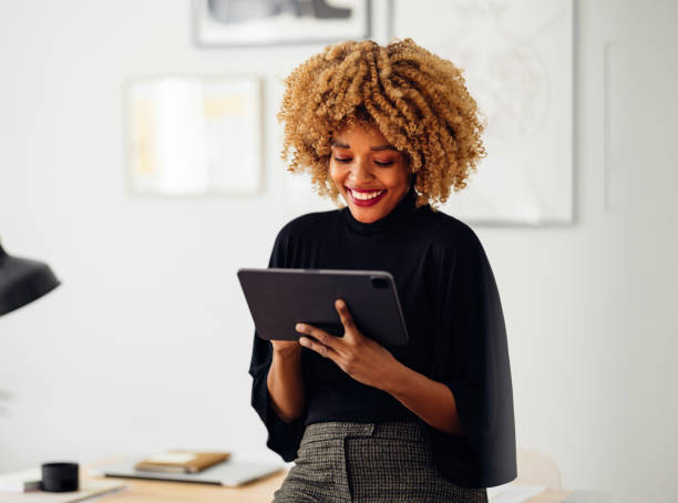 istock Happy Businesswoman Sitting on Her Desk Using Her Tablet 1357935523