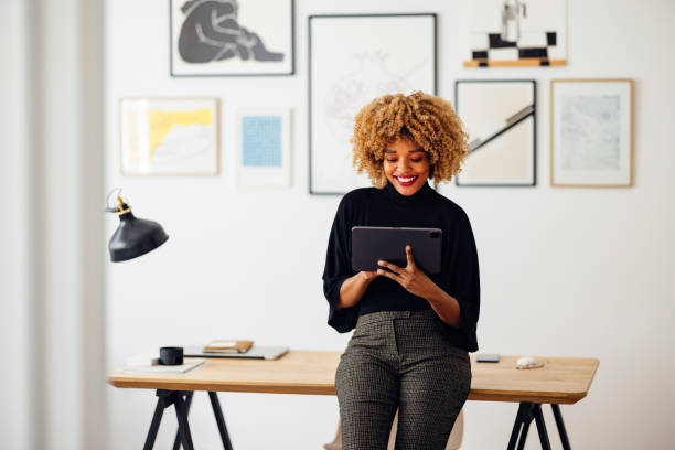 istock Happy Businesswoman Sitting on Her Desk Using Her Tablet 1357935526