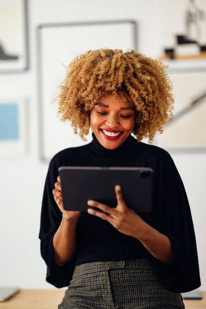 istock Happy Businesswoman Sitting on Her Desk Using Her Tablet 1357935540