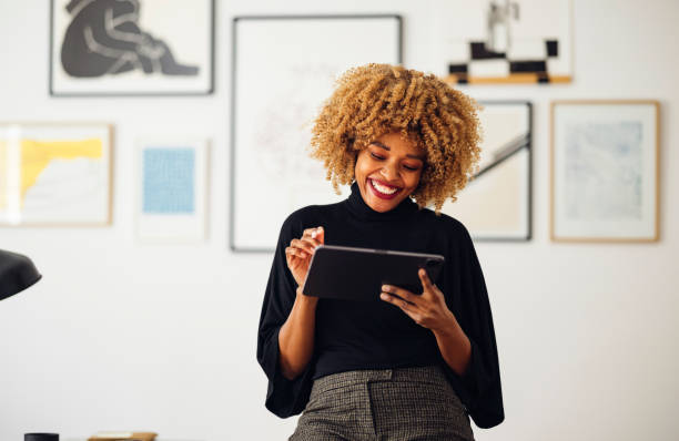 istock Happy Businesswoman Sitting on Her Desk Using Her Tablet 1357935552