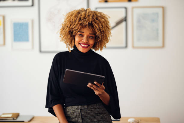 istock Happy Businesswoman Sitting on Her Desk Using Her Tablet 1357935561