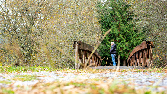 man strolling along a path full of dry leaves in autumn