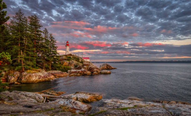 istock Lighthouse Park on a rocky coast during a dramatic cloudy sunset. 1357938018