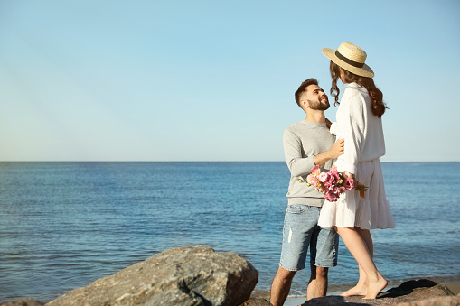 Happy young couple on beach near sea. Honeymoon trip