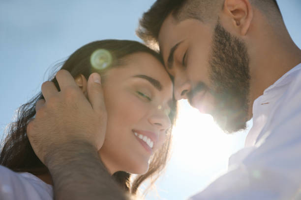 istock Happy young couple against blue sky, low angle view. Honeymoon trip 1357945792