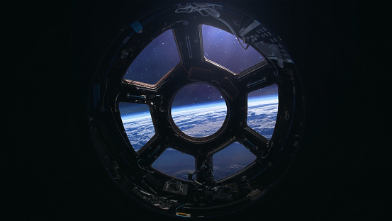 View on Earth and outer sapce from porthole of Cupola on ISS space station. International space station on orbit of Earth planet. Elements of this image furnished by NASA
