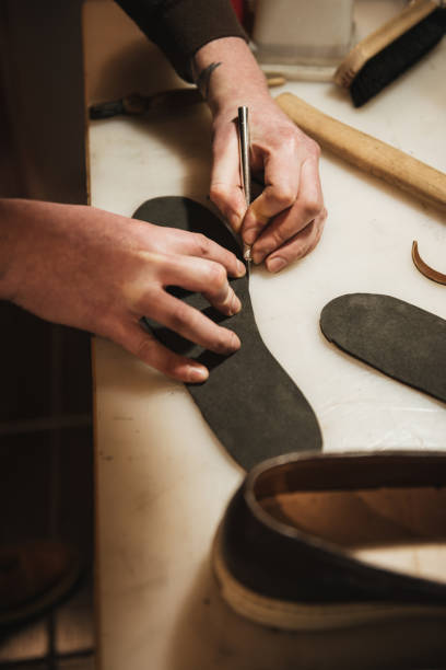 istock Cropped image of young concentrated man shoemaker 1357947134