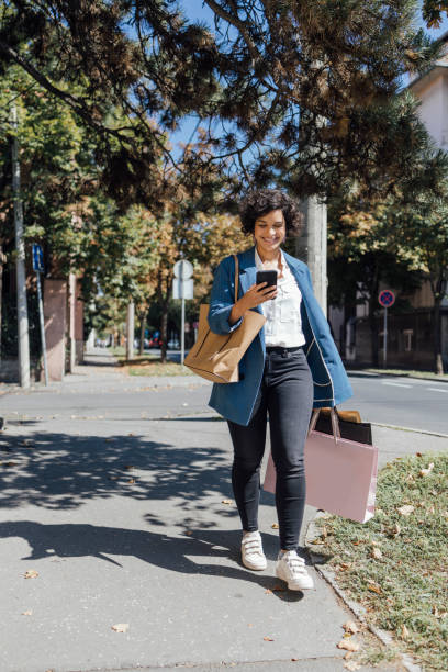istock A Beautiful Mixed-race Female Walking Home From Shopping While Using Her Smartphone 1357947516