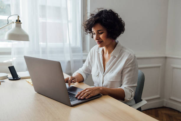 A Beautiful African-American Female Working Online On Her Laptop stock photo