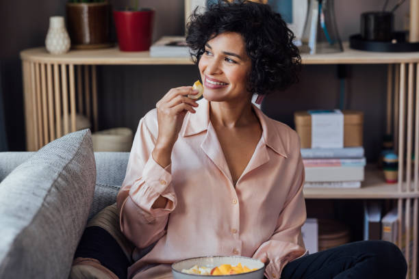 istock A Good-looking African-American Female Eating Some Fruit After Coming Home From Work 1357948081