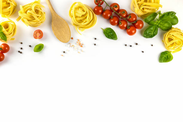 istock Ingredients for cooking Italian pasta on a white plate with place for text. Spaghetti, cherry tomatoes, basil, wooden spoon. Flat lay cooking 1357948082