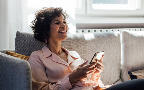 istock A Happy Mixed-race Woman Smiling While Reading Messages On Her Smartphone 1357948148