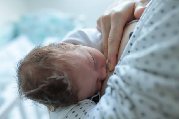 istock Newborn baby being breastfed by her mother 1357949833