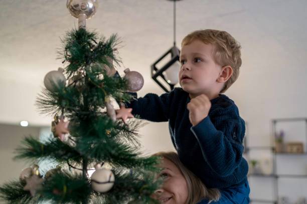 istock Mother decorating Christmas tree with her son 1357949930