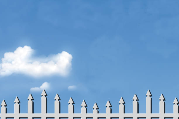 istock White Picket Fence Over Blue Sky with Clouds 1357950879