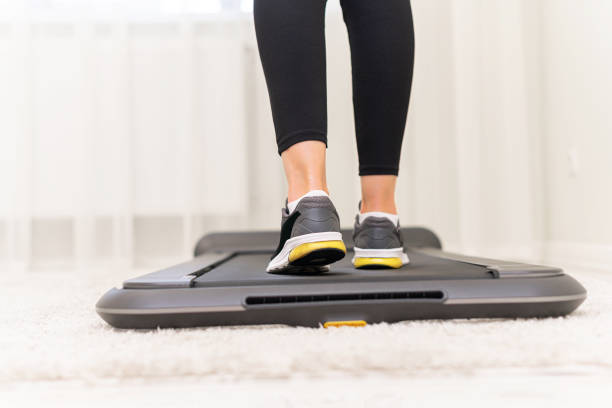 istock Sporty woman using walking treadmill on white background 1357950961