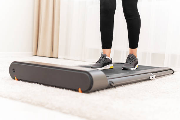 istock Sporty woman using walking treadmill on white background 1357950963
