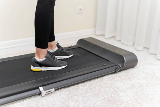 istock Sporty woman using walking treadmill on white background 1357950974