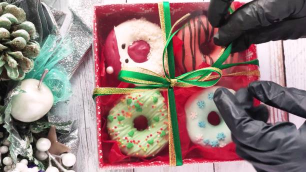 istock unpacking a christmas donut box, donuts with icing and sprinkles 1357952588