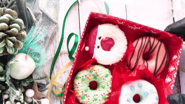 istock unpacking a christmas donut box, donuts with icing and sprinkles 1357952597