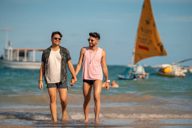 LGBT couple walking hand in hand on the beach