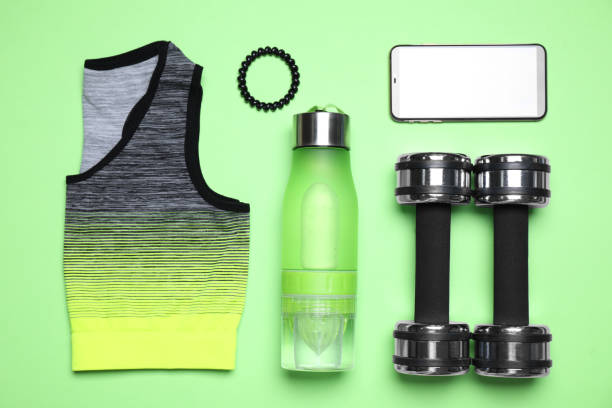 istock Flat lay composition with sports items and mobile phone on green background 1357956081