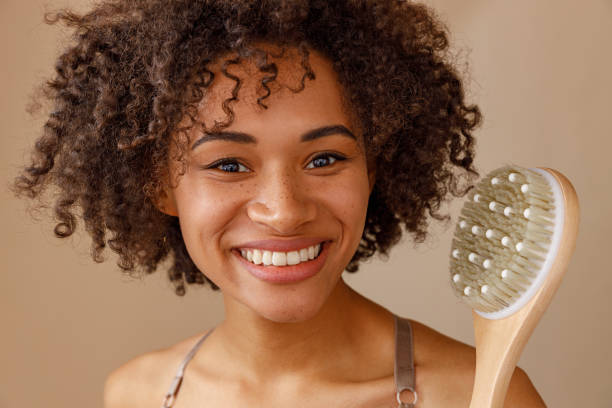 istock Cute female posing with massage brush in studio 1357956346