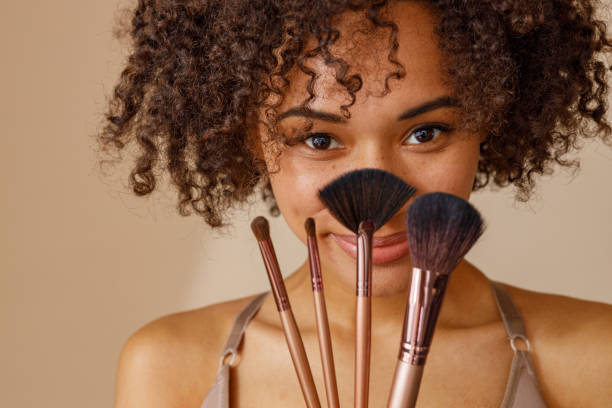 istock Cute lady representing cosmetic brushes in studio 1357956364