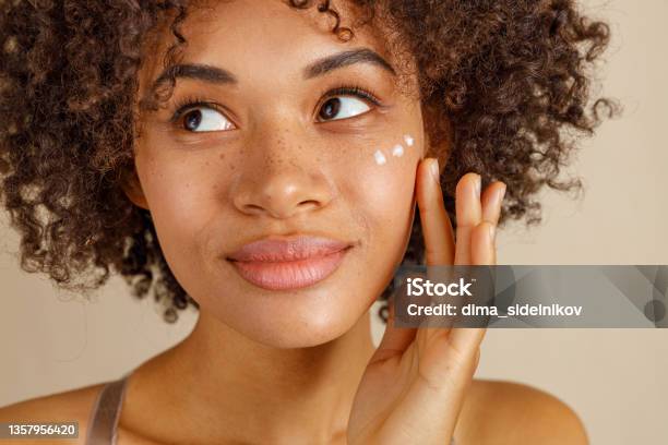 Cute Lady Using Cosmetic Product In Studio Stock Photo - Download Image Now - Skin Care, Women, Moisturizer