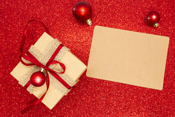 istock christmas gift box and decorations on the red glitter background 1357956445