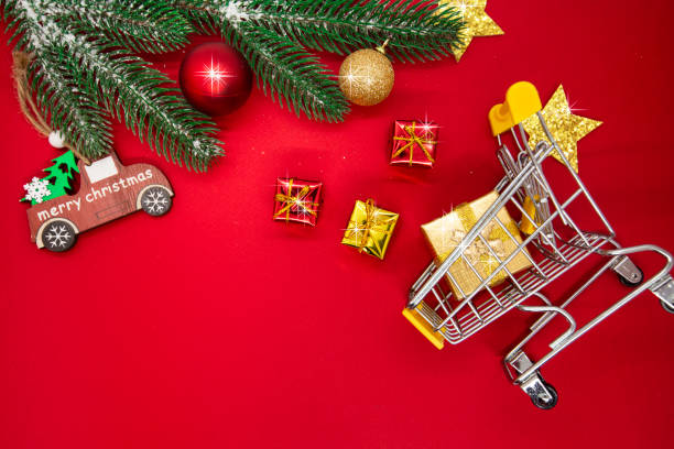 istock christmas background with decorations, shopping cart on red background, copy space. 1357956573