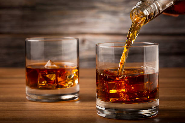 ウイスキーをグラスに注ぐ。 - whisky alcohol bottle hard liquor ストックフォトと画像