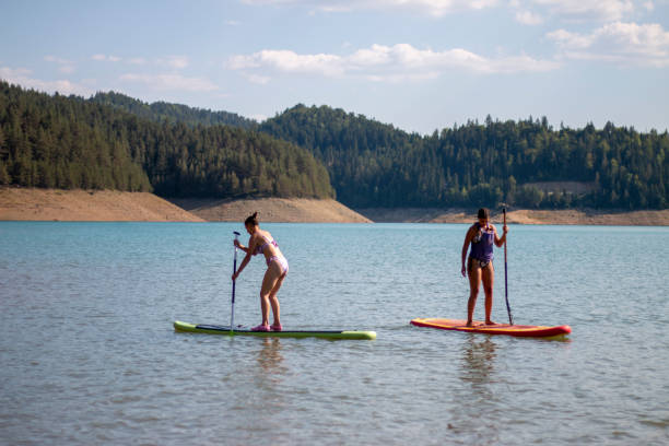 istock Girls standup paddleboarding on the lake 1357960496