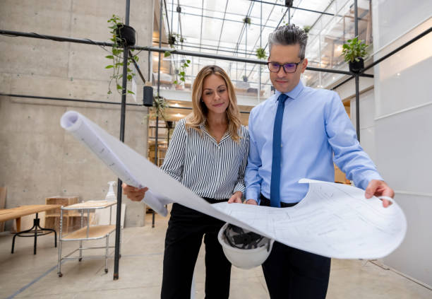 istock Team of architects looking at blueprints at the office 1357967976