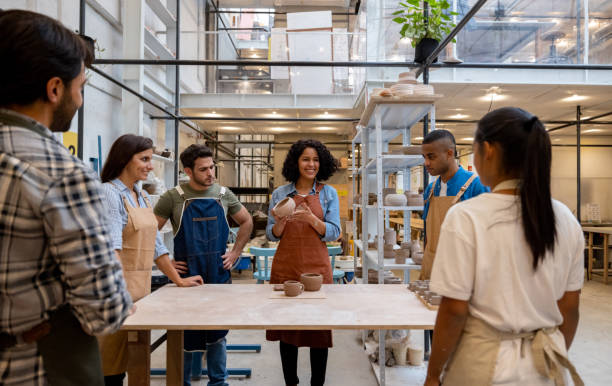 Happy group of people in a pottery class Happy group of Latin American people in a pottery class listening to their teacher - arts and crafts concepts artist sculptor stock pictures, royalty-free photos & images