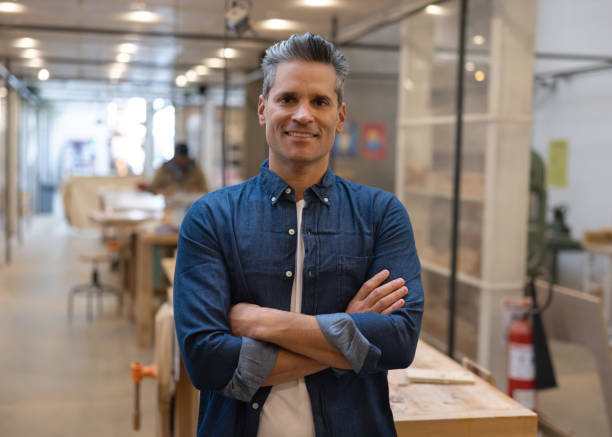 istock Happy business owner working at a carpentry workshop making furniture 1357968048