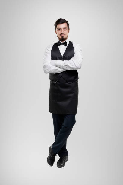 istock Confident waiter in uniform with arms crossed 1357969413