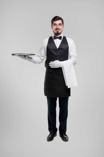 istock Smiling waiter with tray in studio 1357969416