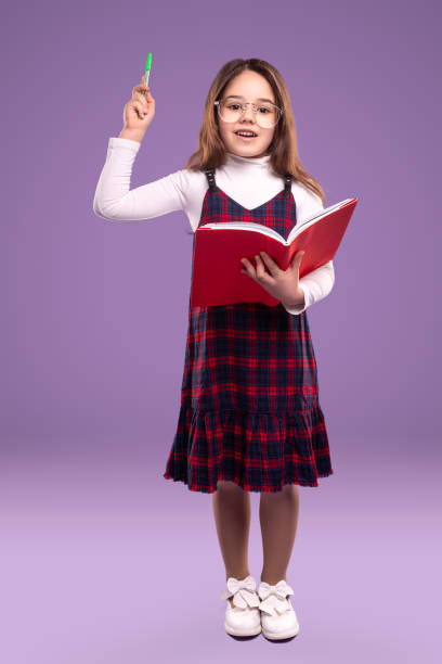 istock Smart schoolgirl with book and pen 1357969460