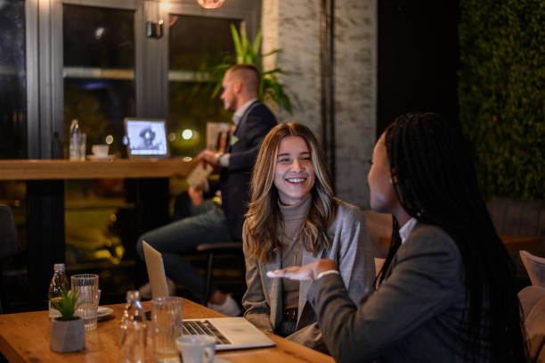 istock Two businesswoman having a meeting in a cafe while using a laptop 1357969584