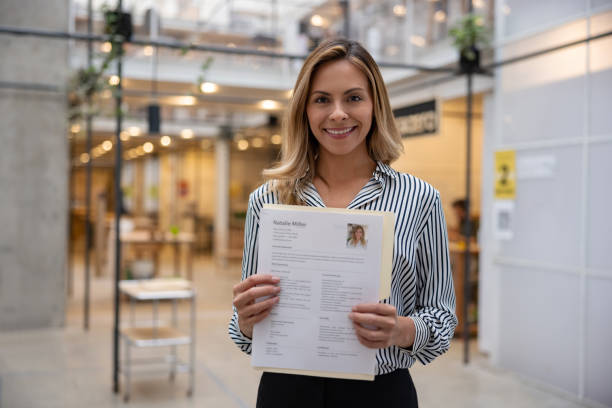 Happy business woman holding her CV for a job interview Portrait of a happy business woman holding her CV for a job interview at an office and looking at the camera smiling - recruitment concepts. **DESIGN ON ALL DOCUMENTS BELONG TO US** good cv stock pictures, royalty-free photos & images