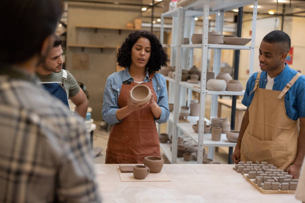 istock Woman teaching group of people in a pottery class 1357976531