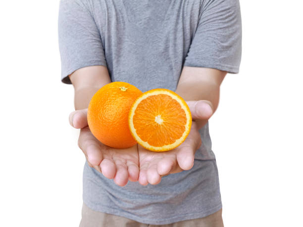 istock fresh orange on the hand male on white Background 1357979100