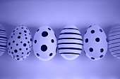 Different graphic hand-painted eggs in Proton Purple neon light.
