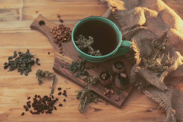 istock fragrant herbal tea in a cup, stands on a wooden surface next to dry herbs and berries 1357990202